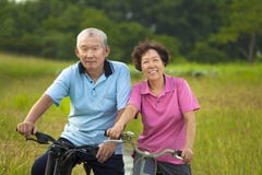 Het gelukkige Aziatische oudstenpaar biking in Park royalty-vrije stock afbeelding Het gelukkige Aziatische oudstenpaar biking in Park royalty-vrije stock afbeelding