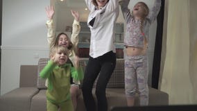Het gelukkige familie wortel schieten voor het voetbalteam thuis Familiesprong die omhoog, zich bij het genoteerde doel verheugen stock footage Het gelukkige familie wortel schieten voor het voetbalteam thuis Familiesprong die omhoog, zich bij het genoteerde doel verheugen stock footage