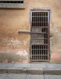 Het gesloten geroeste ijzer verspert celdeur en doorstane grunge steenmuur in gesloten verlaten gevangenis royalty-vrije stock foto's Het gesloten geroeste ijzer verspert celdeur en doorstane grunge steenmuur in gesloten verlaten gevangenis royalty-vrije stock foto's