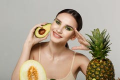 Het gezonde mooie donkerbruine meisje glimlachen, die de camera met avocado in hand dichtbijgelegen gezicht bekijken stock afbeeldingen Het gezonde mooie donkerbruine meisje glimlachen, die de camera met avocado in hand dichtbijgelegen gezicht bekijken stock afbeeldingen