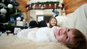 Het glimlachen kind dicht omhoog portret, gelukkig meisje die op bed, Kerstmisvooravond die, zusters thuis liggen pret hebben stock videobeelden Het glimlachen kind dicht omhoog portret, gelukkig meisje die op bed, Kerstmisvooravond die, zusters thuis liggen pret hebben stock videobeelden