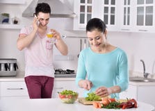 Het glimlachende paar eet salade in de keuken royalty-vrije stock afbeeldingen Het glimlachende paar eet salade in de keuken royalty-vrije stock afbeeldingen