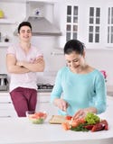 Het glimlachende paar eet salade in de keuken stock afbeeldingen Het glimlachende paar eet salade in de keuken stock afbeeldingen