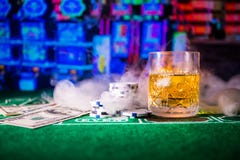Het gokken, fortuin, spel en vermaakconcept - sluit omhoog van casinospaanders en wiskyglas op lijst royalty-vrije stock foto's Het gokken, fortuin, spel en vermaakconcept - sluit omhoog van casinospaanders en wiskyglas op lijst royalty-vrije stock foto's