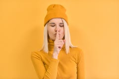 Het horizontale portret die van mooie vrouwen dringende vinger tegen haar lippen, Shh, stilte zeggen, vraagt stil te zijn, draagt stock foto's Het horizontale portret die van mooie vrouwen dringende vinger tegen haar lippen, Shh, stilte zeggen, vraagt stil te zijn, draagt stock foto's