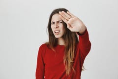 Het jonge Europese in wijfje met boze unsatisfied uitdrukkingsholding dient eindegebaar in proberend om haar gezicht te behandele Royalty-vrije Stock Fotografie Het jonge Europese in wijfje met boze unsatisfied uitdrukkingsholding dient eindegebaar in proberend om haar gezicht te behandele Royalty-vrije Stock Fotografie