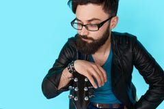 Het jonge jongen stellen met gitaar tegen blauwe muur stock foto Het jonge jongen stellen met gitaar tegen blauwe muur stock foto