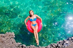Het jonge mooie meisje in bikini zwemt in een tropische overzees op een rubb royalty-vrije stock afbeelding Het jonge mooie meisje in bikini zwemt in een tropische overzees op een rubb royalty-vrije stock afbeelding