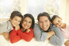 Het jonge Spaanse Familie Ontspannen op Sofa At Home stock afbeelding Het jonge Spaanse Familie Ontspannen op Sofa At Home stock afbeelding