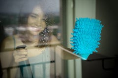 Het jonge venster van de vrouwenwas gelukkig meisje die in handschoenen fles houden royalty-vrije stock fotografie Het jonge venster van de vrouwenwas gelukkig meisje die in handschoenen fles houden royalty-vrije stock fotografie