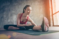 Het jonge vrij sportieve sportieve meisje uitrekken zich op een tapijt na cro stock foto's Het jonge vrij sportieve sportieve meisje uitrekken zich op een tapijt na cro stock foto's