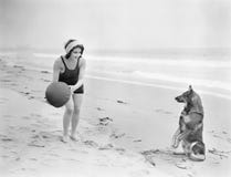Het jonge vrouw spelen met haar hond en bal op het strand (Alle afgeschilderde personen leven niet langer en geen landgoed bestaa stock afbeeldingen Het jonge vrouw spelen met haar hond en bal op het strand (Alle afgeschilderde personen leven niet langer en geen landgoed bestaa stock afbeeldingen