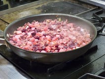 Het koken op de fornuisbovenkant met een pan royalty-vrije stock foto's Het koken op de fornuisbovenkant met een pan royalty-vrije stock foto's