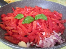 Het koken van eigengemaakte tomatensaus die verse de zomertomaten, ui, knoflook en basilicum gebruiken Italiaans recept Royalty-vrije Stock Foto Het koken van eigengemaakte tomatensaus die verse de zomertomaten, ui, knoflook en basilicum gebruiken Italiaans recept Royalty-vrije Stock Foto