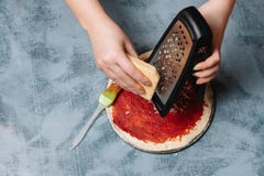 Het koken van Italiaanse pizza met tomaten, kip, olijven op houten achtergrond Tomatensaus op het deeg door de hand van de vrouw stock afbeeldingen Het koken van Italiaanse pizza met tomaten, kip, olijven op houten achtergrond Tomatensaus op het deeg door de hand van de vrouw stock afbeeldingen