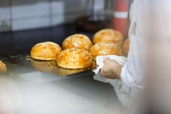Het koken van sesambroodjes en chef-kok dient de keuken in royalty-vrije stock foto's Het koken van sesambroodjes en chef-kok dient de keuken in royalty-vrije stock foto's