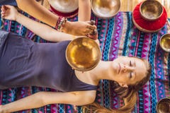 Het koper zingende kom van Nepal Boedha bij kuuroordsalon Jonge mooie vrouw die de zingende kommen van de massagetherapie in het royalty-vrije stock afbeelding Het koper zingende kom van Nepal Boedha bij kuuroordsalon Jonge mooie vrouw die de zingende kommen van de massagetherapie in het royalty-vrije stock afbeelding