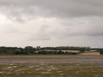 Het lege getijde van de estuariumscène uit met land van het seaguls het donkere land stock fotografie Het lege getijde van de estuariumscène uit met land van het seaguls het donkere land stock fotografie