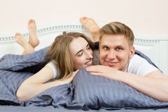 Het leuke houdende van paar ligt op het bed in de slaapkamer in de ochtend Jong gelukkig paar die in bed en glimlach liggen stock foto Het leuke houdende van paar ligt op het bed in de slaapkamer in de ochtend Jong gelukkig paar die in bed en glimlach liggen stock foto