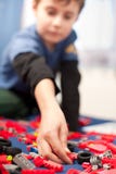 Het leuke jong geitje spelen met plastic blokken Stock Fotografie Het leuke jong geitje spelen met plastic blokken Stock Fotografie