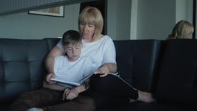 Het mamma helpt mijn son do homework in de woonkamer Het concept een gelukkige familie stock footage Het mamma helpt mijn son do homework in de woonkamer Het concept een gelukkige familie stock footage