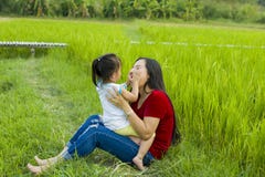 Het mamma van het levensstijlportret en dochter in geluk bij de buitenkant in de weide, Grappige Aziatische familie in een padiev stock foto Het mamma van het levensstijlportret en dochter in geluk bij de buitenkant in de weide, Grappige Aziatische familie in een padiev stock foto