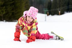 Het meisje in de winteruitrusting viel terwijl het ski?en royalty-vrije stock afbeeldingen Het meisje in de winteruitrusting viel terwijl het ski?en royalty-vrije stock afbeeldingen
