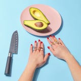 Het meisje eet met een mes en vertakt zich een stuk van avocado op een roze plaat Minimalisticconcept Hoogste mening royalty-vrije stock foto Het meisje eet met een mes en vertakt zich een stuk van avocado op een roze plaat Minimalisticconcept Hoogste mening royalty-vrije stock foto