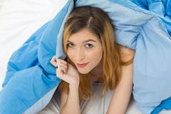Het meisje heeft een vage glimlach op haar gezicht Zij ligt alleen in bed aan Stock Foto Het meisje heeft een vage glimlach op haar gezicht Zij ligt alleen in bed aan Stock Foto