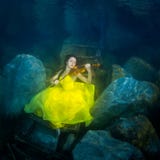 Het meisje met een viool onder water royalty-vrije stock afbeelding Het meisje met een viool onder water royalty-vrije stock afbeelding