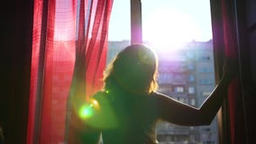 Het meisje vroege ochtend loopt aan het venster en opent het De zon` s stralen gaan door het glas over, verlichten de ruimte en stock videobeelden Het meisje vroege ochtend loopt aan het venster en opent het De zon` s stralen gaan door het glas over, verlichten de ruimte en stock videobeelden