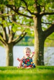 Het meisjeszitting van de blondepeuter in park met bellen stock fotografie Het meisjeszitting van de blondepeuter in park met bellen stock fotografie