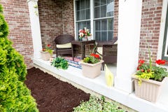 Het met mulch bedekken van bloembedden rond het huis stock foto Het met mulch bedekken van bloembedden rond het huis stock foto