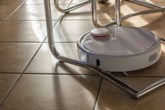 Het moderne robotachtige vacuüm maakt in alle hoeken schoon stock foto Het moderne robotachtige vacuüm maakt in alle hoeken schoon stock foto