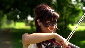 Het mooie jonge meisje spelen op elektrische viool op mooi park stock footage Het mooie jonge meisje spelen op elektrische viool op mooi park stock footage