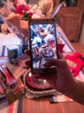 Het nemen van foto van verjaardagsgeschenk met smartphone royalty-vrije stock fotografie Het nemen van foto van verjaardagsgeschenk met smartphone royalty-vrije stock fotografie
