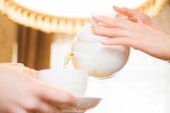 Het ontspannen van de vrouw drinkt thee De vrouwen gieten groene thee in een witte Kop royalty-vrije stock afbeelding Het ontspannen van de vrouw drinkt thee De vrouwen gieten groene thee in een witte Kop royalty-vrije stock afbeelding