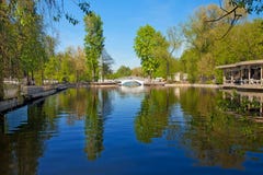 Het park van de stad met een brug en een vijver Stock Afbeelding Het park van de stad met een brug en een vijver Stock Afbeelding