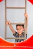 Het portret van Aziatische jongens beklimt de ladder in de speelplaats stock afbeelding Het portret van Aziatische jongens beklimt de ladder in de speelplaats stock afbeelding