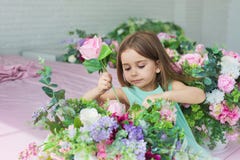 Het portret van een mooi meisje in een turkooise kleding plaatst bloemen in een studio royalty-vrije stock afbeelding Het portret van een mooi meisje in een turkooise kleding plaatst bloemen in een studio royalty-vrije stock afbeelding