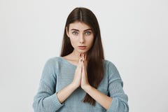 Het portret van leuke volwassen vrouw met lang haar en de engel bekijken, kijkend camera terwijl holding indienen bidden of bedel royalty-vrije stock fotografie Het portret van leuke volwassen vrouw met lang haar en de engel bekijken, kijkend camera terwijl holding indienen bidden of bedel royalty-vrije stock fotografie