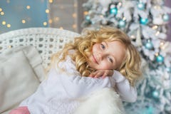 Het portret van mooi meisje zit en droomt op een stoel in Kerstmistijd stock afbeelding Het portret van mooi meisje zit en droomt op een stoel in Kerstmistijd stock afbeelding
