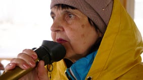 Het portret van vrouwenzeeman in regenjas spreekt in megafoon op het schip stock video Het portret van vrouwenzeeman in regenjas spreekt in megafoon op het schip stock video