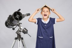 Het schoolmeisje behandelde haar hoofd met handboek en schreeuw bekijkend het kader, die zich bij de telescoop bevinden stock afbeelding Het schoolmeisje behandelde haar hoofd met handboek en schreeuw bekijkend het kader, die zich bij de telescoop bevinden stock afbeelding