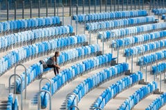 Het sexy meisje stellen bij stadion met de rugzak Fitness het meisje met sporten komt in zwarte beenkappen voor zittend op de zet stock foto's Het sexy meisje stellen bij stadion met de rugzak Fitness het meisje met sporten komt in zwarte beenkappen voor zittend op de zet stock foto's