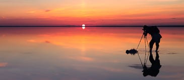 Het silhouet van de alleen mens neemt een beeld van een trillende die zonsondergang in ondiepe wateren van soltmeer wordt weerspi royalty-vrije stock afbeelding Het silhouet van de alleen mens neemt een beeld van een trillende die zonsondergang in ondiepe wateren van soltmeer wordt weerspi royalty-vrije stock afbeelding