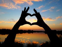 Het silhouet van dient de vorm van een hart tegen de achtergrond van een mooie zonsondergang in stock afbeeldingen Het silhouet van dient de vorm van een hart tegen de achtergrond van een mooie zonsondergang in stock afbeeldingen