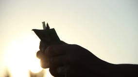 Het silhouet van zonstralen van het tellen van de handen van het geldmannetje bij schemer stock videobeelden Het silhouet van zonstralen van het tellen van de handen van het geldmannetje bij schemer stock videobeelden