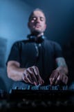 Het spelen van DJ huis en technomuziek in een nachtclub Het mengen van en het controleren van de muziek royalty-vrije stock foto Het spelen van DJ huis en technomuziek in een nachtclub Het mengen van en het controleren van de muziek royalty-vrije stock foto