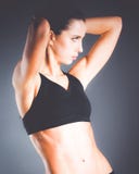 Het spier jonge vrouw stellen in sportkleding tegen zwarte achtergrond Stock Foto Het spier jonge vrouw stellen in sportkleding tegen zwarte achtergrond Stock Foto